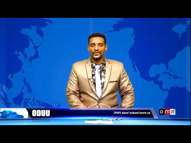 a man in a suit sitting on a desk